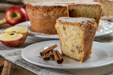 piece of sponge cake or chiffon cake with apples so soft and delicious sliced ​​with ingredients: cinnamon, eggs, flour, apples on wooden table. Home bakery concept for background and wallpaper