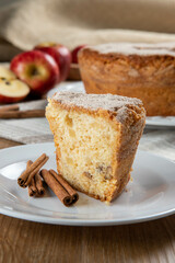 piece of sponge cake or chiffon cake with apples so soft and delicious sliced ​​with ingredients: cinnamon, eggs, flour, apples on wooden table. Home bakery concept for background and wallpaper