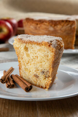piece of sponge cake or chiffon cake with apples so soft and delicious sliced ​​with ingredients: cinnamon, eggs, flour, apples on wooden table. Home bakery concept for background and wallpaper