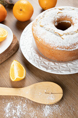 Moist orange fruit cake on plate with orange slices on wooden table. Delicious breakfast, traditional English tea time. Orange cake recipe.