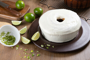 Moist lemon fruit cake on plate with lemon slices on wooden table. Delicious breakfast, traditional tea time. Lemon cake recipe.
