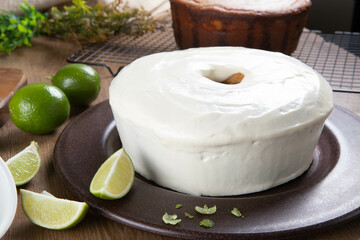 Moist lemon fruit cake on plate with lemon slices on wooden table. Delicious breakfast, traditional tea time. Lemon cake recipe.