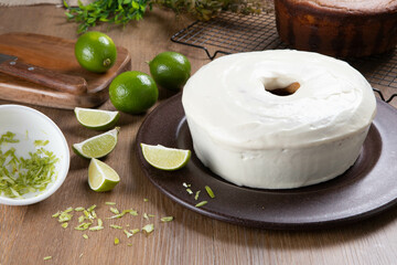 Moist lemon fruit cake on plate with lemon slices on wooden table. Delicious breakfast, traditional tea time. Lemon cake recipe.