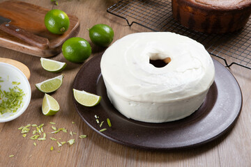 Moist lemon fruit cake on plate with lemon slices on wooden table. Delicious breakfast, traditional tea time. Lemon cake recipe. Top view.