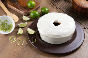 Moist lemon fruit cake on plate with lemon slices on wooden table. Delicious breakfast, traditional tea time. Lemon cake recipe. Top view.