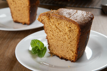Close up piece of Brazilian corn cake made with a type of corn flour (Fuba). On a wooden party table. Typical sweets of the June festival. Cornmeal cake
