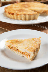 Close up piece of Chicken pie with cottage cheese, tomatoes, onion and olives on wooden table and white plate