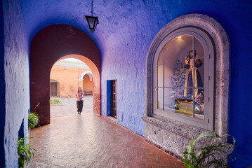 Turista latina entrando al claustro de los naranjos del monasterio Santa Catalina en Arequipa