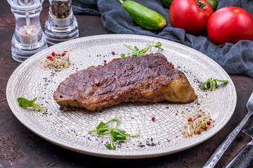 roast beef Steak Trytip on grey plate on dark stone table