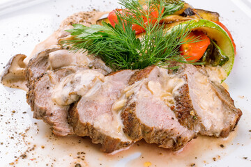 Sliced Roast Veal steak with mushroom sauce and grilled vegetables macro close up