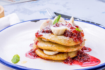 pancake with bananas and raspberry jam on plate