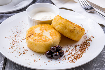 cheesecakes from cottage cheese with sour cream on white plate macro close up