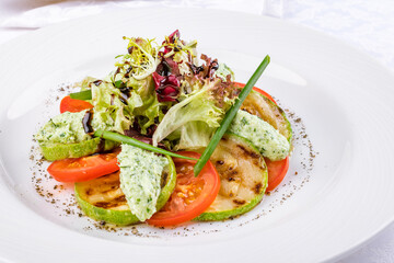 grilled vegetables on a white plate side view