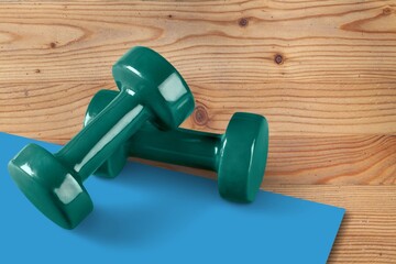 Healthcare and home exercises concepts. Fitness dumbbell and roller on the floor in the gym.