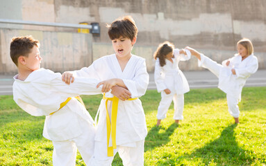 Fototapeta na wymiar Young male children are trying in sparring to use new moves at karate class