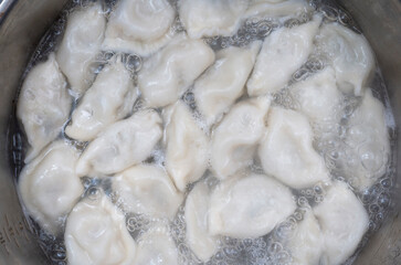 Meat dumplings are boiled in a pot of boiling water