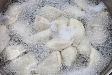 Meat dumplings are boiled in a pot of boiling water