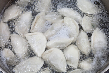 Meat dumplings are boiled in a pot of boiling water