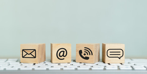 Concept of contact us. wooden cube blocks with contact icons on computer keyboard. symbol of...
