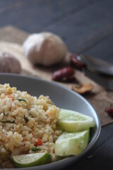 Pork fried rice is a common street food in Thailand. Served on a black wooden table.