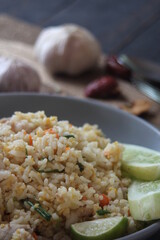Pork fried rice is a common street food in Thailand. Served on a black wooden table.