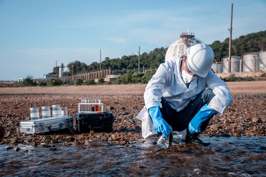 Scientist wearing protective uniform and glove under working water analysis and water quality by get fishes dead to check effected case in laboratory is environment pollution problem concept.