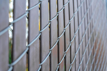 Selective focus of a chain link fence with brown privacy strips at Japanese Friendship Garden