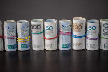 Banknotes rolled and tied together with a rubber band placed on a table.