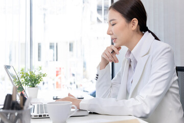 Businesswoman using laptop to work, Asian woman working in the office, World of technology and internet communication, Using computers to conduct financial transactions because the convenience.