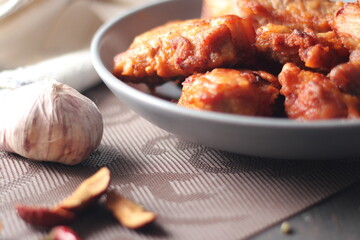 Fried Pork Belly with Fish Sauce Served on a Gray plate on a black wooden floor.
