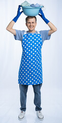 man in blue apron, rubber gloves, blue t-shirt, jeans. homeowner holding a basin with dirty...