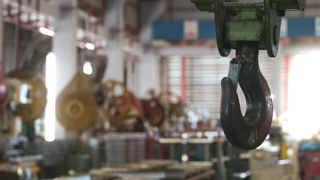 Closeup of swivel chain hook crane of electric hoist in factory workshop, pullersSwivel chain hook equipment for pullers, industry lifting machine