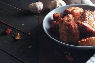 Fried Pork Belly with Fish Sauce Served on a Gray plate on a black wooden floor.