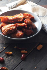 Fried Pork Belly with Fish Sauce Served on a Gray plate on a black wooden floor.