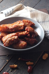 Fried Pork Belly with Fish Sauce Served on a Gray plate on a black wooden floor.