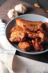 Fried Pork Belly with Fish Sauce Served on a Gray plate on a black wooden floor.