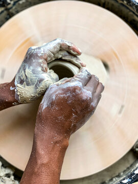 A Man Throwing A Clay Mug On A Potters Wheel