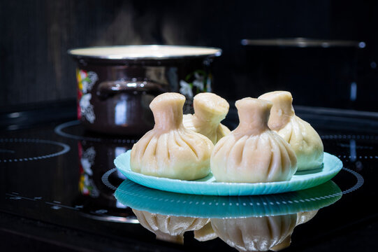 georgian dampling known as khinkali in georgian on black plate on black background