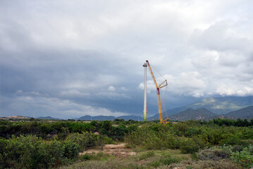 Fototapeta premium Landscape with construction site of wind turbine towers. Industrial concept for sustainable growth and reduce climate change and global warming