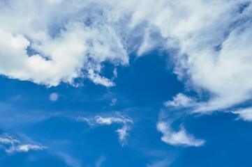 Naklejka na ściany i meble Bright blue sky and white clouds in the shape of imaginary animals. 