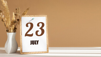 july 23. 23th day of month, calendar date.White vase with dead wood next to cork board with numbers. White-beige background with striped shadow. Concept of day of year, time planner, summer month