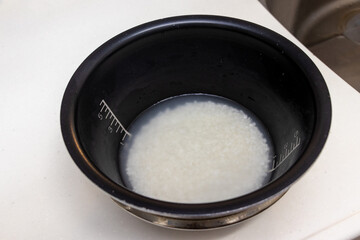 黒い釜の中で水に浸された白いお米