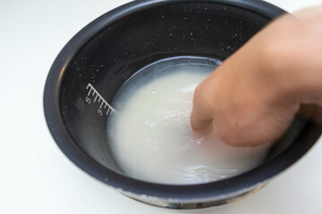 黒いボウルの中でお米をとぐ