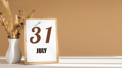 july 31. 31th day of month, calendar date.White vase with dead wood next to cork board with numbers. White-beige background with striped shadow. Concept of day of year, time planner, summer month