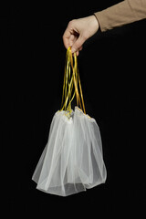 Hand holding reusable grocery bags from net, reusable packaging for fruits and vegetables, empty...