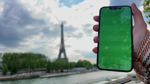 Advertising a tour to Paris, the travel agency can place its data on a green screen chromatey phone against the background of the eiffel tower. High quality 4k footage