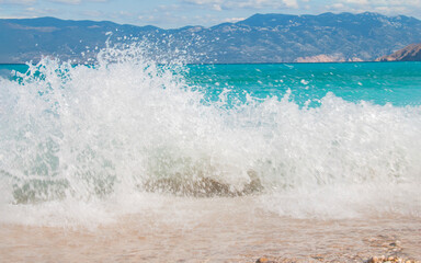 Fototapeta premium Beautiful turquoise sea, big wave and mountains on a warm sunny day. Seascape banner. Ideal place to relax