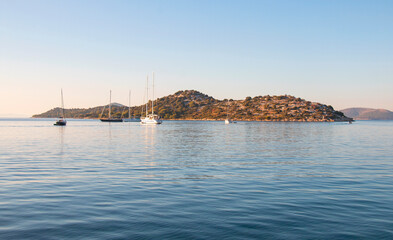 Naklejka premium Beautiful turquoise sea at dawn, yachts laid up on a warm sunny morning. Seascape banner. Ideal place to relax