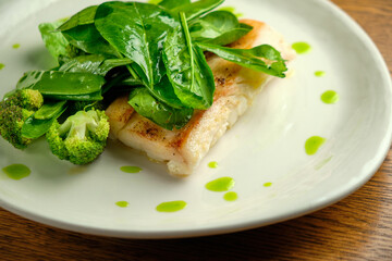 Pike perch fish fillet with spinach leaves
