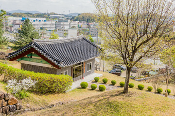 Tourist information building in historical park with city buildings in background.